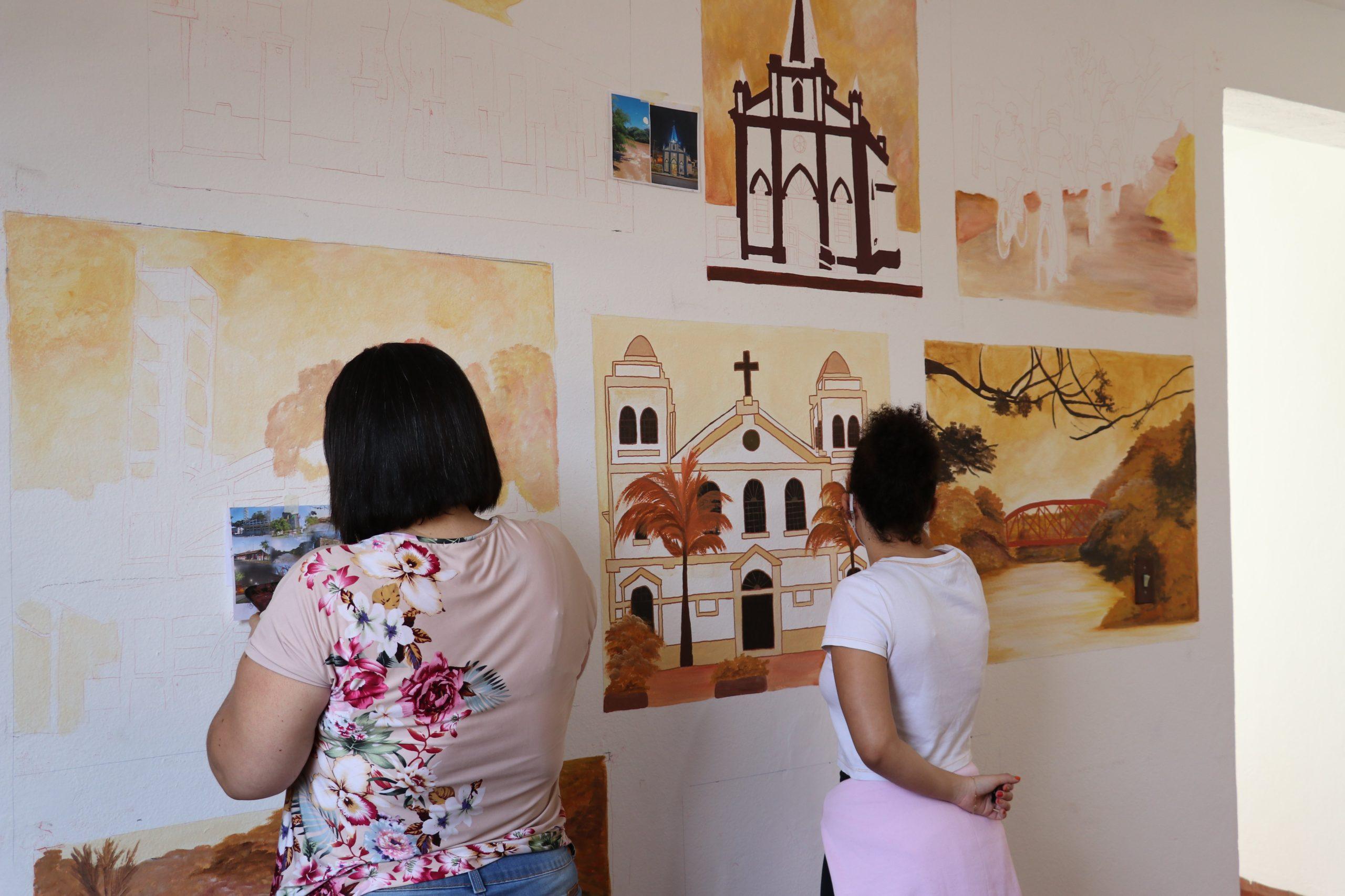 Artista faz pinturas ilustrativas na sala de recepção da Secretaria de Turismo